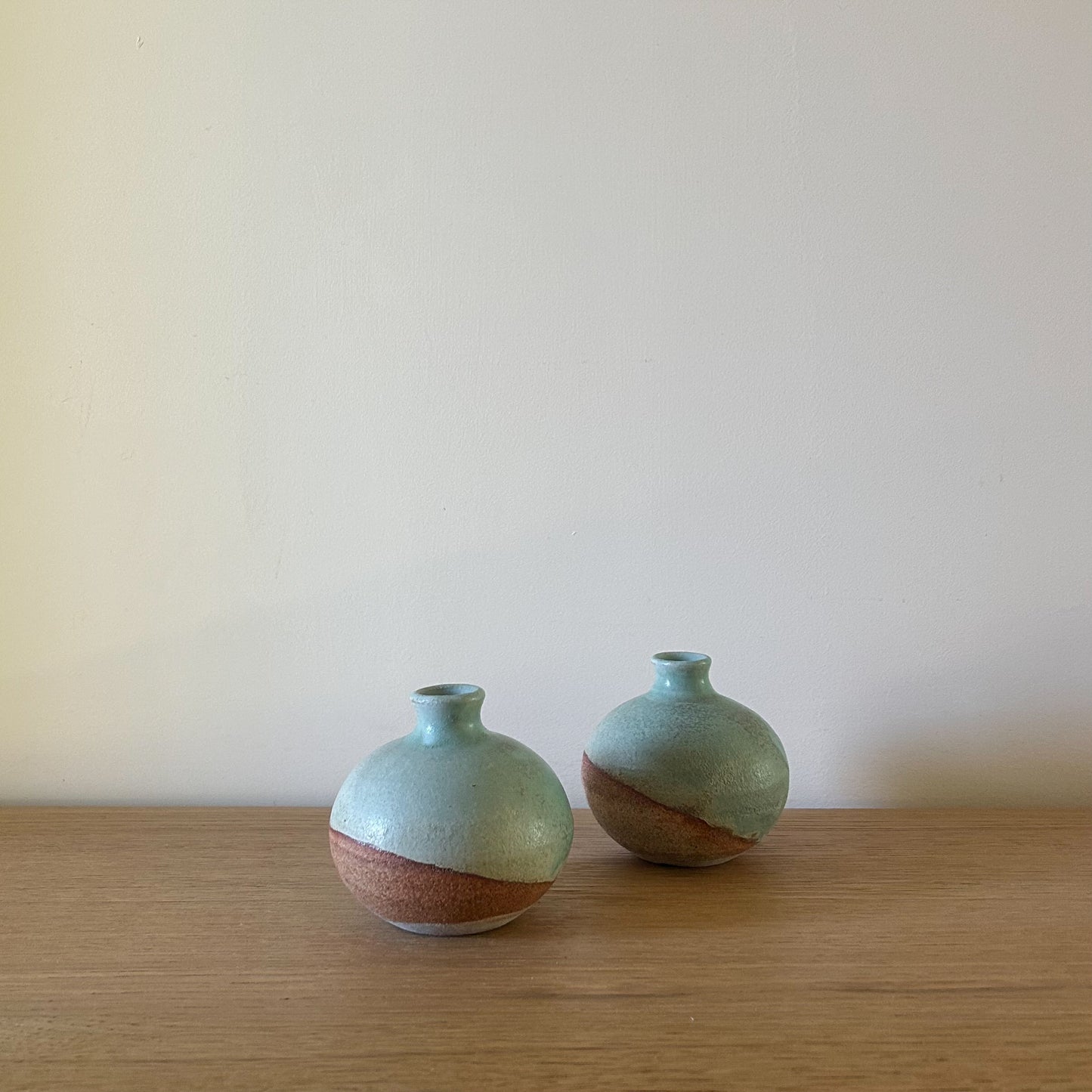 Azure Bloom Vase by Betsey Carter Ceramics with a diagonal turquoise glaze and raw clay base, perfect for small floral arrangements.