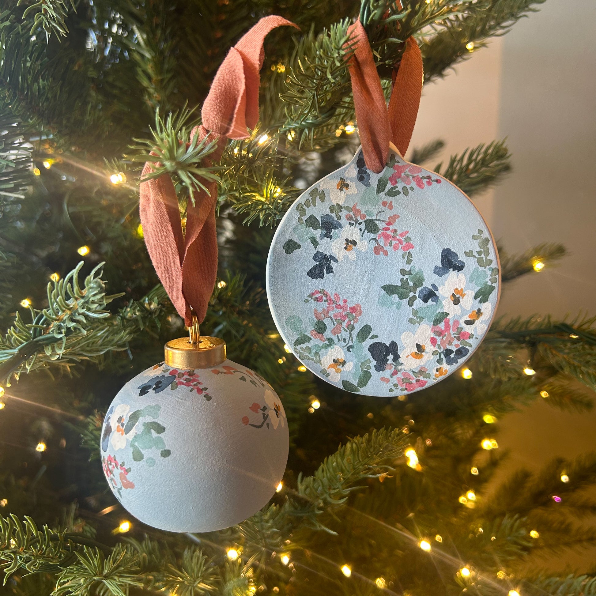 Hand Painted Ornament by Kate Nelson with floral brushstrokes and chiffon ribbon, each unique, and packaged in a linen bag for gifting and storage.