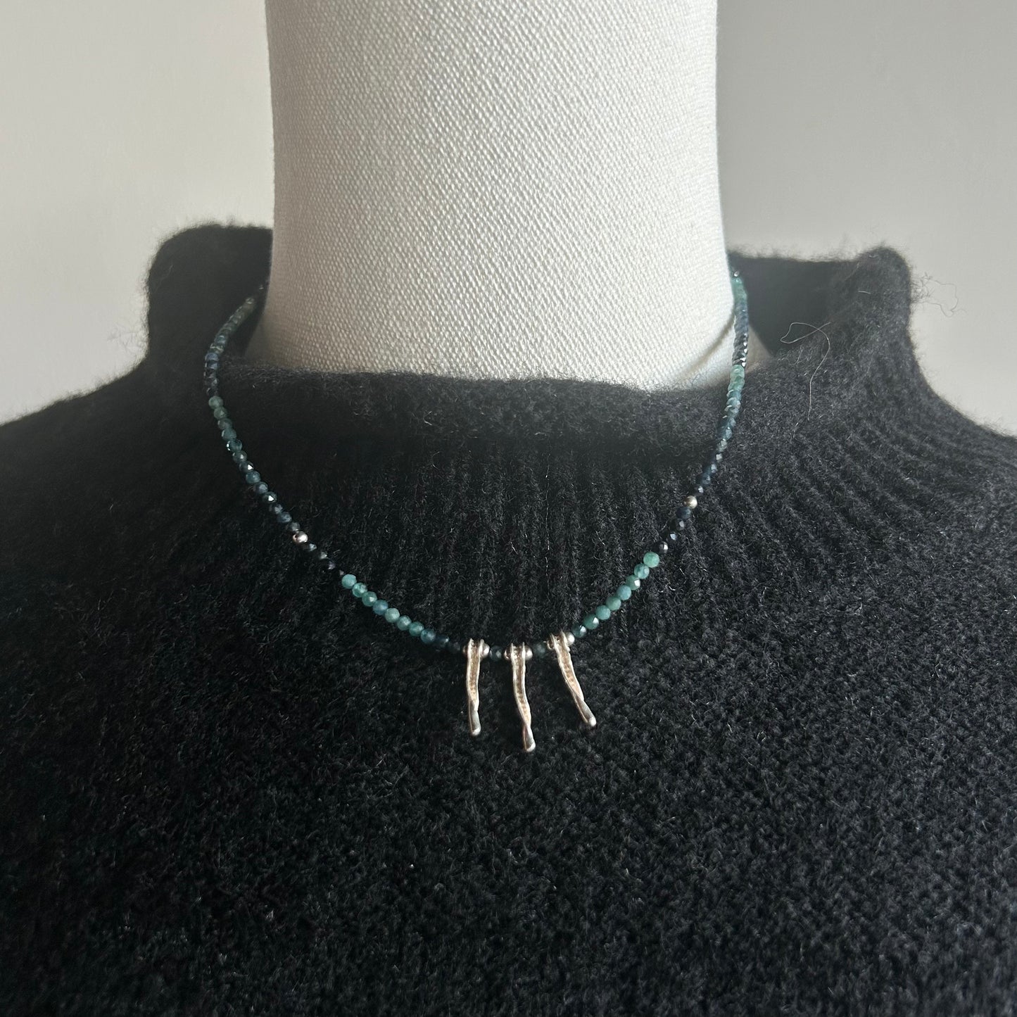 A handcrafted Green Tourmaline Necklace featuring green tourmaline stones with sterling silver spikes on a sterling silver chain with clasp.