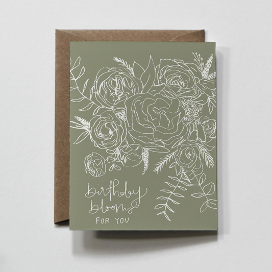 A hand-drawn Birthday Blooms Greeting Card featuring a delicate floral design, folded A2 size (4.25x5.5 inches) with a matching pointed envelope. Printed on 100% recycled thick cardstock and packaged in a compostable sleeve.